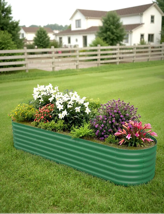 Green metal raised garden bed with flowers on a grassy lawn